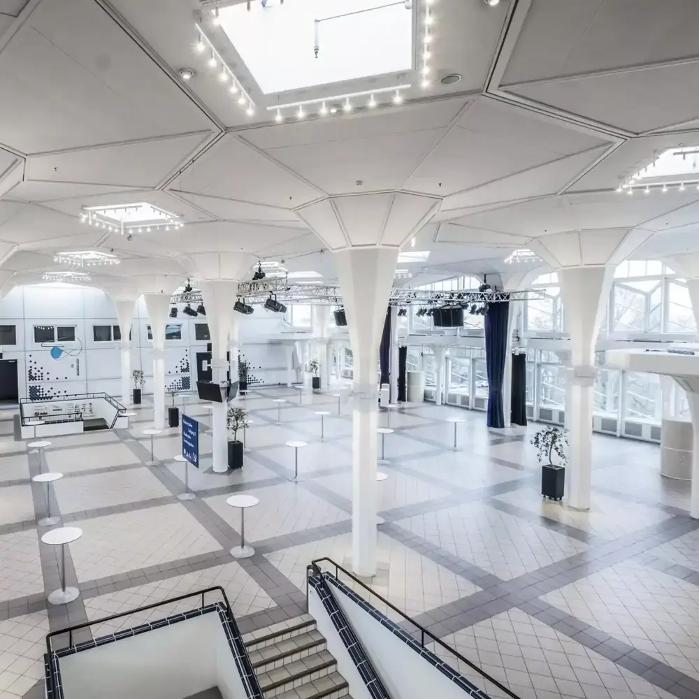 Den lyse foyer i Musikhuset Esbjerg med hvide søjler og højt loft, klar til udstilling og netværk.
